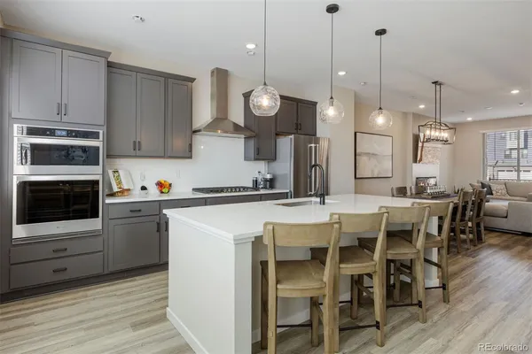 a kitchen with a dining table chairs stainless steel appliances and cabinets