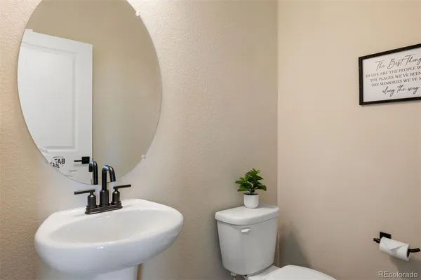 a bathroom with a toilet a sink and a mirror