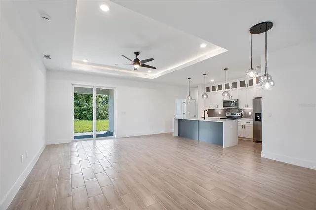 a view of kitchen with stainless steel appliances granite countertop a sink and a refrigerator