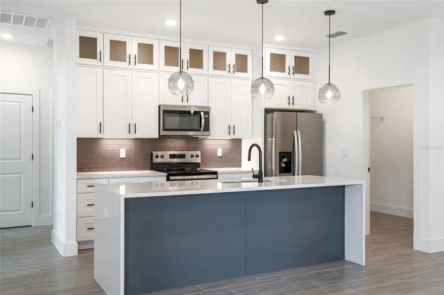 a kitchen with stainless steel appliances a sink a stove and a refrigerator