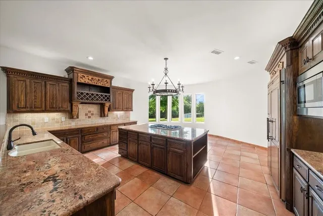 a kitchen with stainless steel appliances a stove sink and cabinets