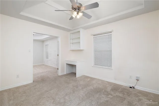 an empty room with a fireplace and a ceiling fan