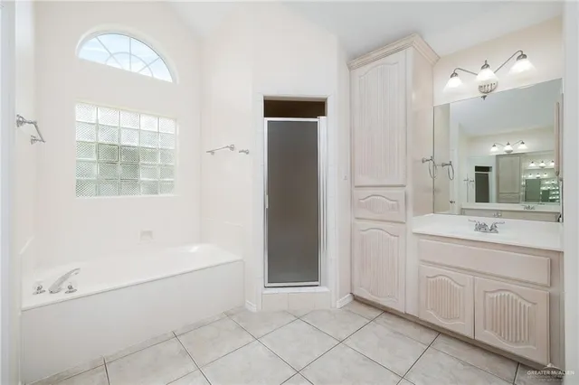 a spacious bathroom with a bathtub sink and mirror