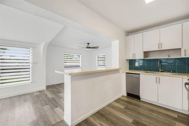 a kitchen with granite countertop white cabinets and white appliances