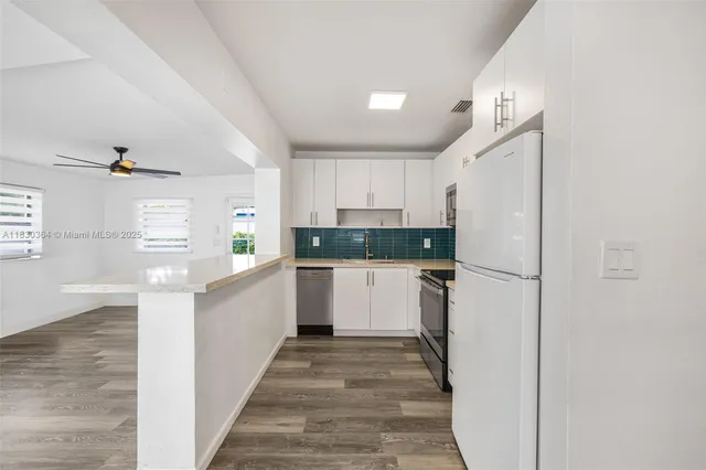 a kitchen with white cabinets and stainless steel appliances