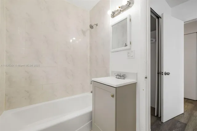 a bathroom with a bathtub sink and mirror