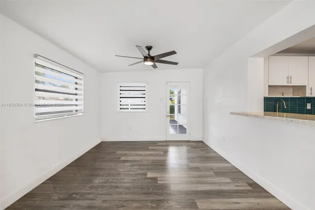 a view of a livingroom with a ceiling fan window and wooden floor