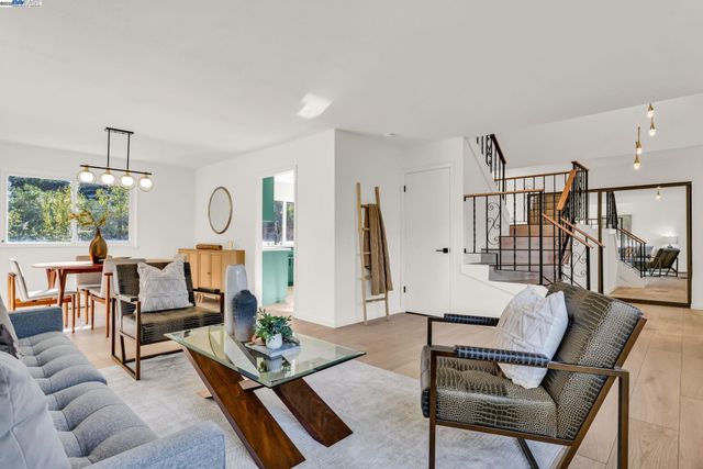 a living room with furniture a rug and white walls