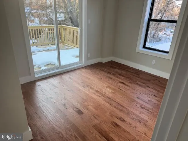 an empty room with wooden floor and door