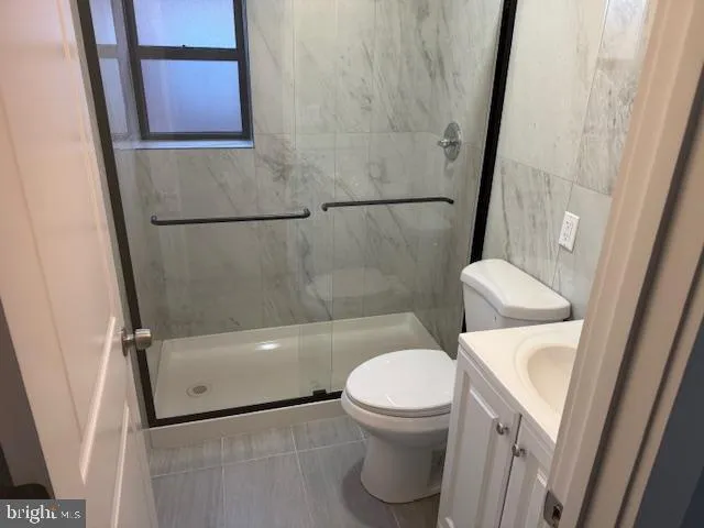 a white toilet sitting next to a bath tub and a shower