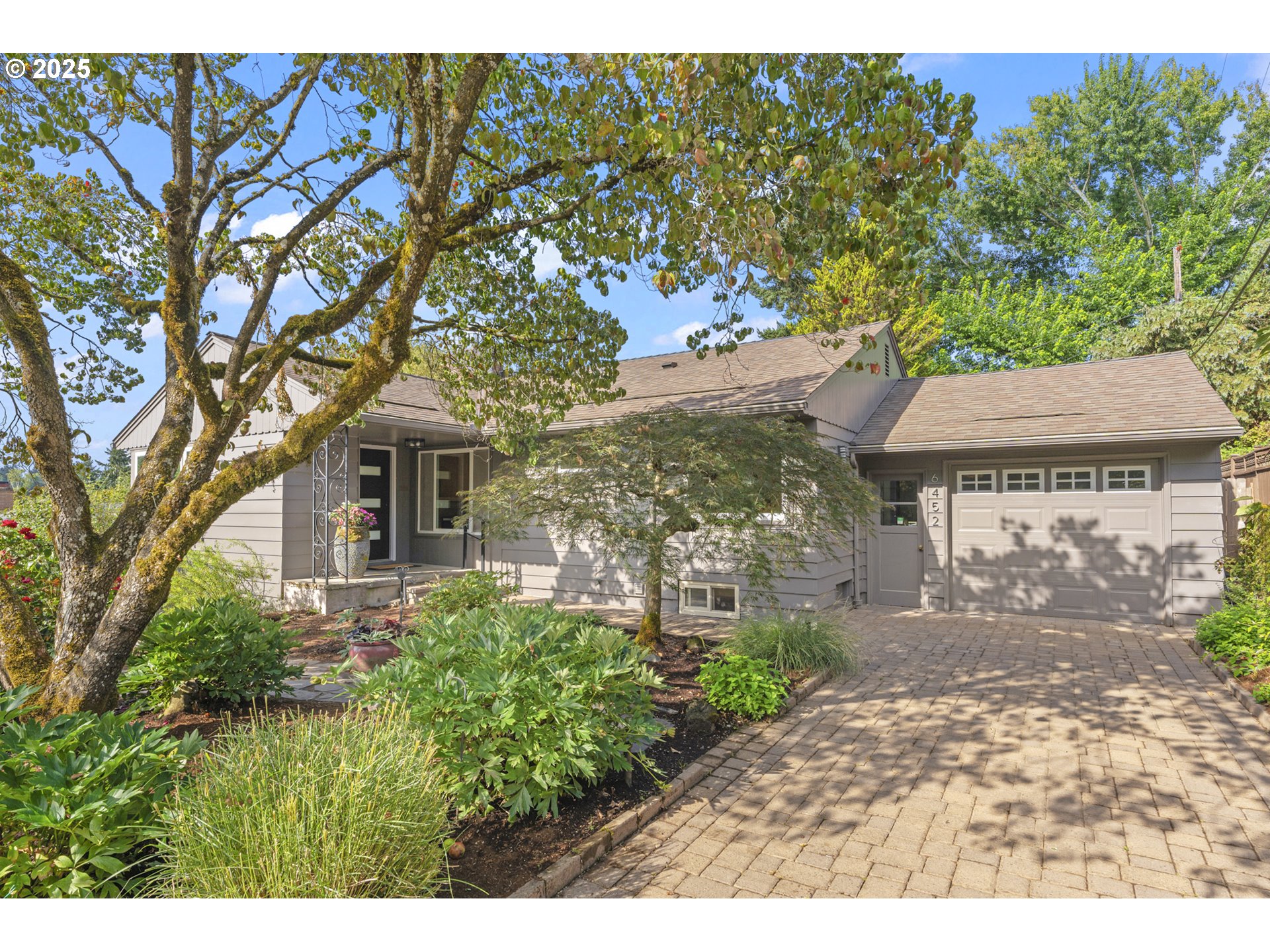 a front view of a house with a garden