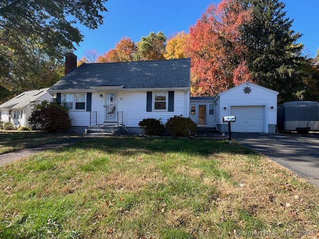 a front view of house with yard and trees in the background