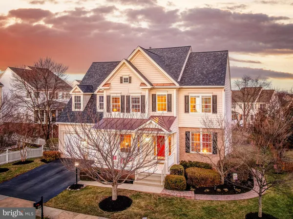 a view of a white house next to a yard with big trees