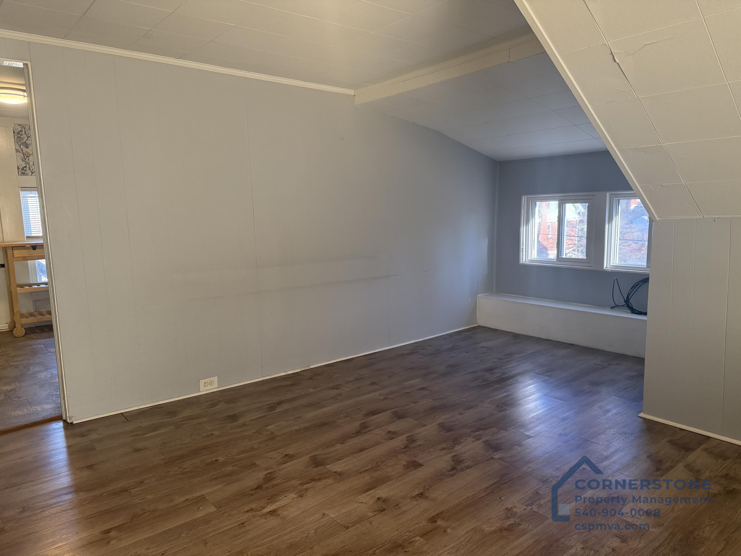 2423 Lofton Road Southwest, Unit 2 Roanoke, VA 24015 - Photo 11 of 14 an empty room with wooden floor and windows
