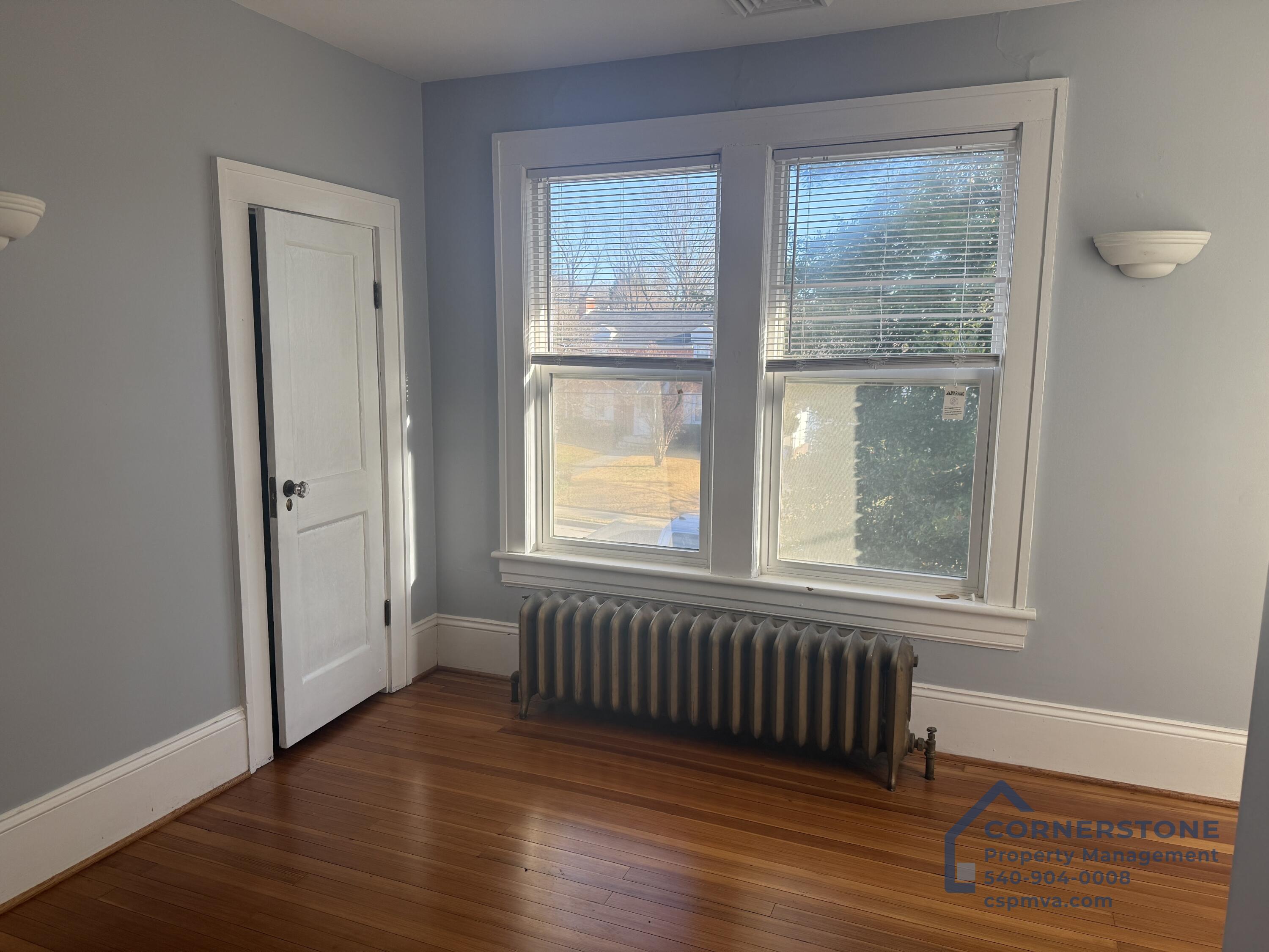 2423 Lofton Road Southwest, Unit 2 Roanoke, VA 24015 - Photo 8 of 14 an empty room with wooden floor and windows