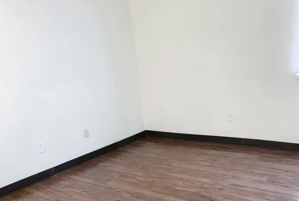 a view of an empty room with wooden floor