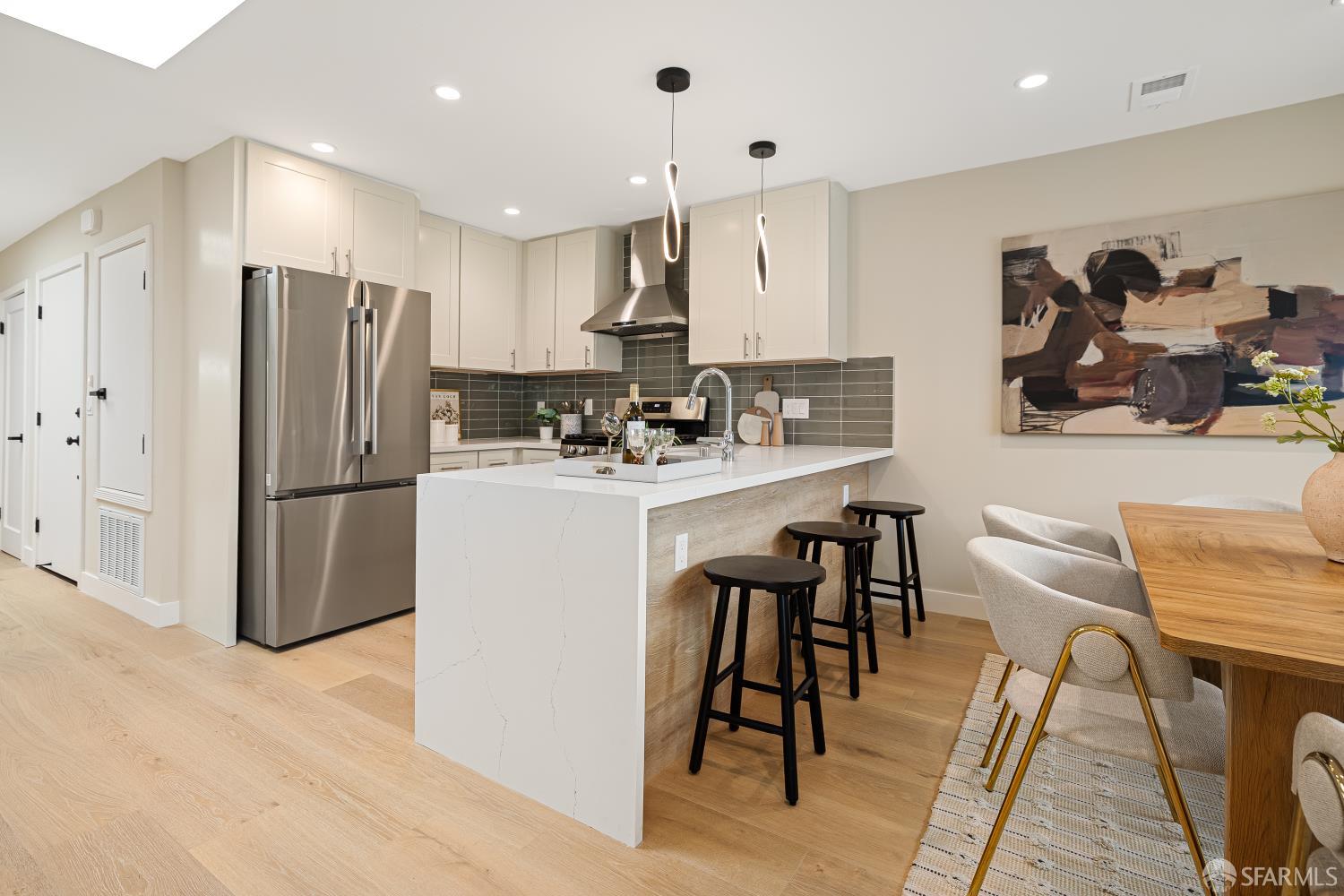 537 Russia Avenue San Francisco, CA 94112 - Photo 15 of 69 a kitchen with stainless steel appliances kitchen island granite countertop a refrigerator a stove a sink a dining table and chairs with wooden floor