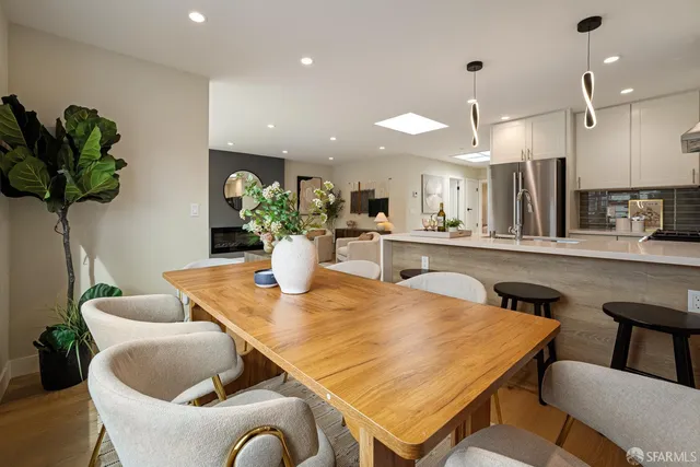 a dining hall with stainless steel appliances granite countertop a dining table and chairs