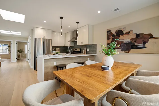 a kitchen with stainless steel appliances kitchen island granite countertop a sink and a refrigerator