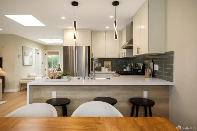 a kitchen with stainless steel appliances granite countertop a sink a stove and a refrigerator