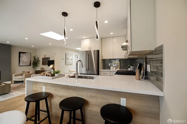 a kitchen with a sink and living room view