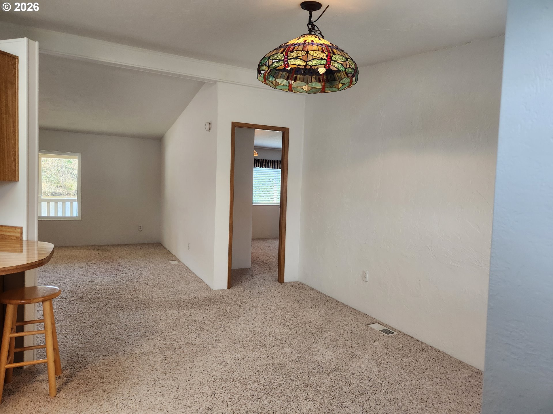 100 River Bend Road, Unit 24 Reedsport, OR 97467 - Photo 11 of 36 an empty room with a chandelier fan and wooden floor