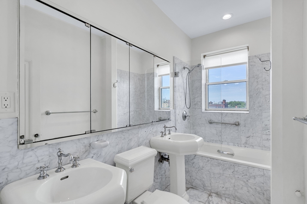 311 Commonwealth Avenue, Unit 71 Boston, MA 02115 - Photo 12 of 19 a bathroom with a bathtub shower sink and mirror