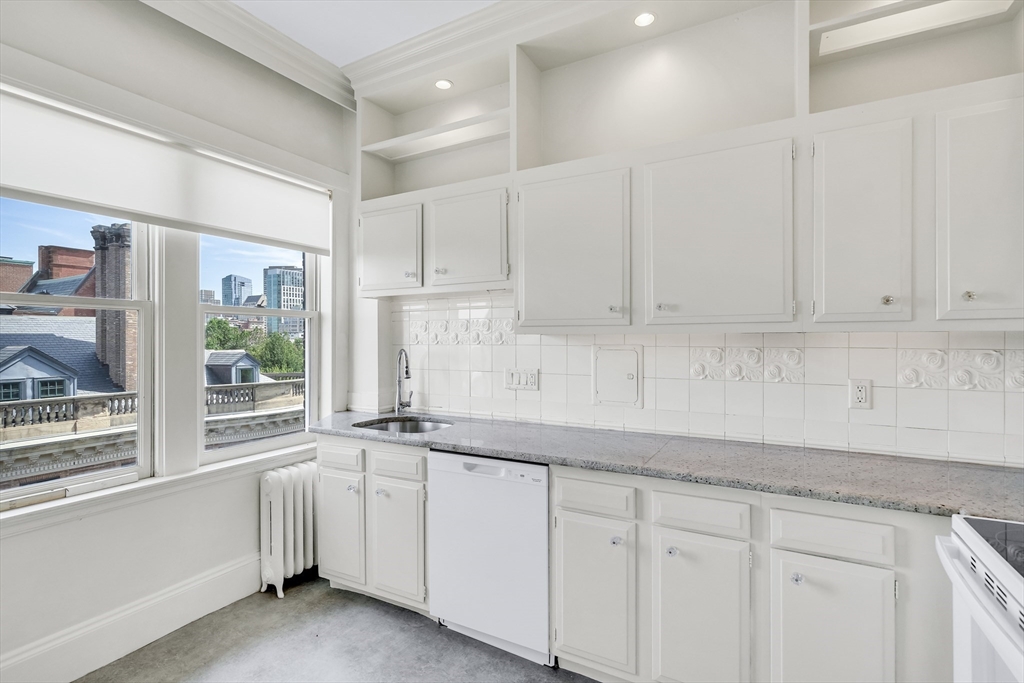 311 Commonwealth Avenue, Unit 71 Boston, MA 02115 - Photo 7 of 19 a kitchen with granite countertop white cabinets and white appliances