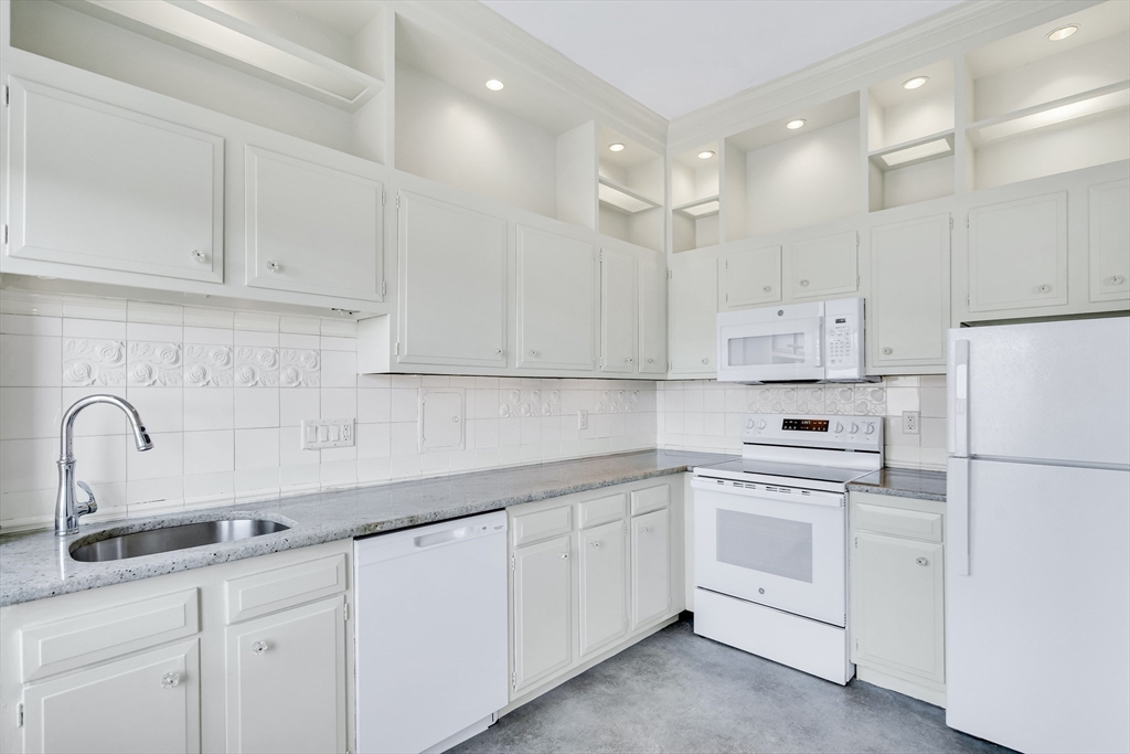 311 Commonwealth Avenue, Unit 71 Boston, MA 02115 - Photo 8 of 19 a kitchen with white cabinets sink and white appliances