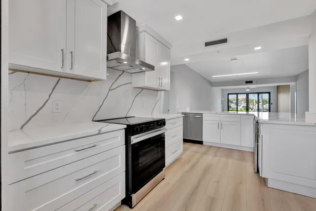 a kitchen with a stove cabinets and wooden floor
