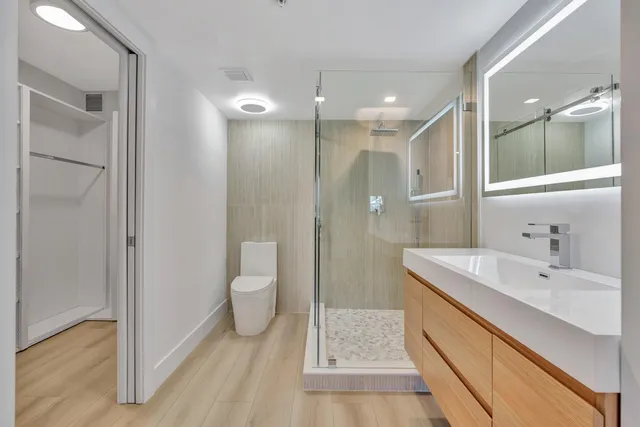 a bathroom with a sink a toilet and shower
