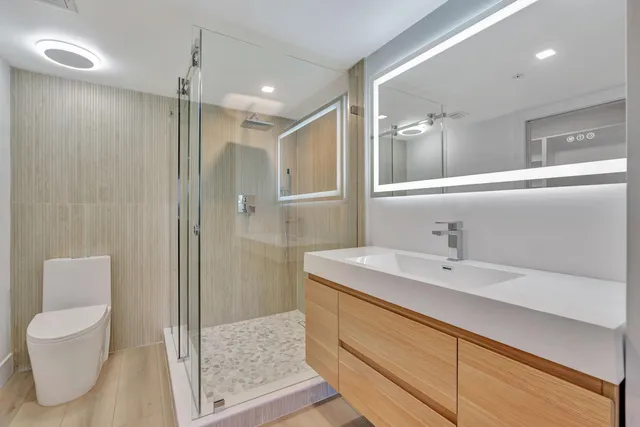 a bathroom with a sink a toilet and shower