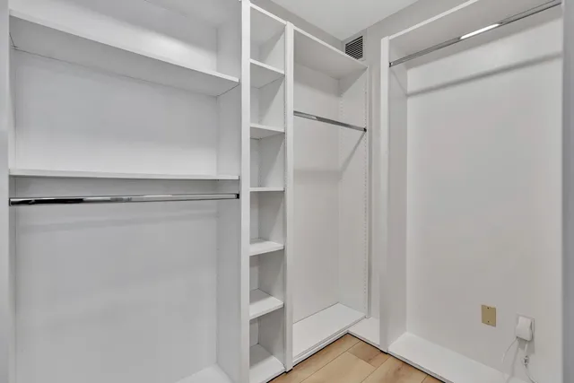 a view of walk in closet with empty racks