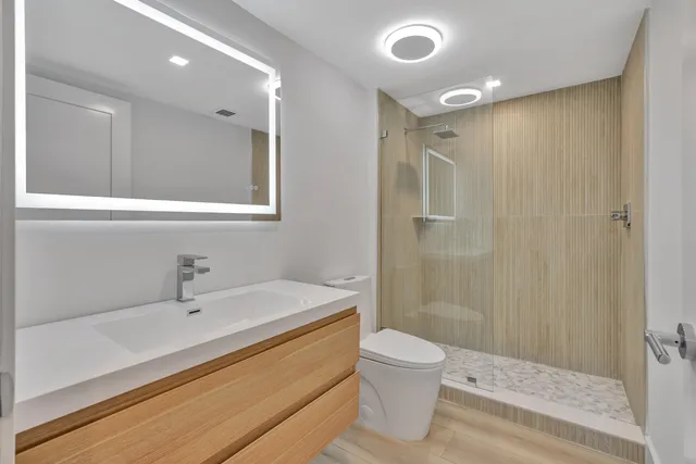 a bathroom with a sink a toilet and shower