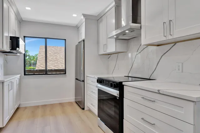 a kitchen with stainless steel appliances granite countertop a sink a stove and a refrigerator