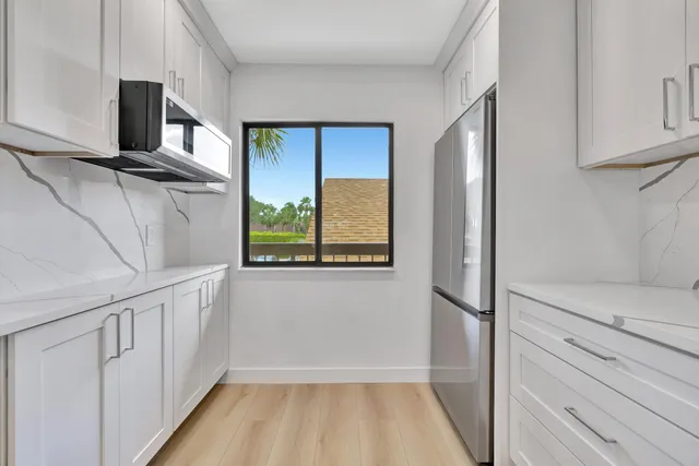 a view of a kitchen with wooden floor and electronic appliances