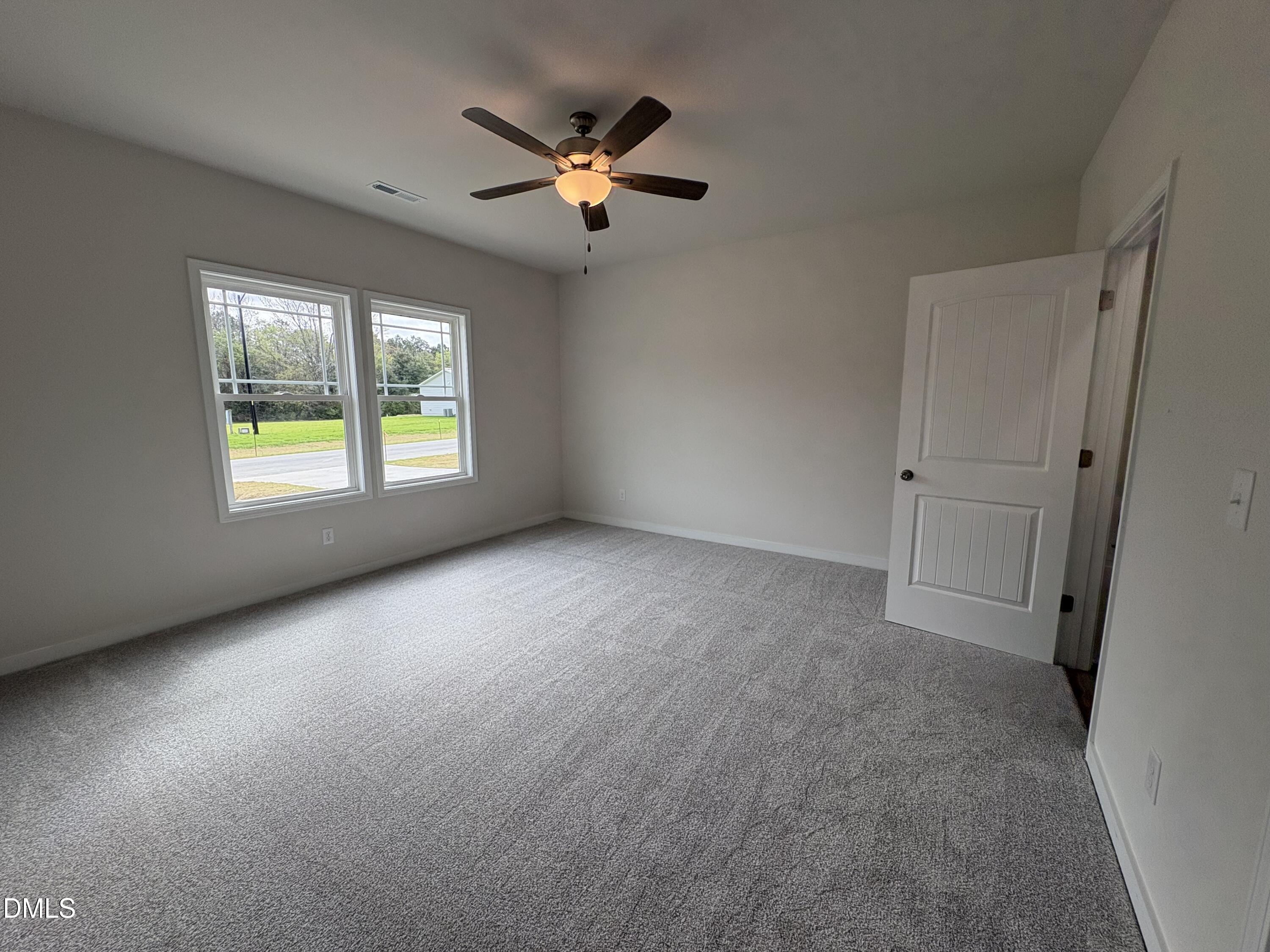 253 Jacobs Ridge Drive Four Oaks, NC 27524 - Photo 8 of 17 an empty room with windows and fan