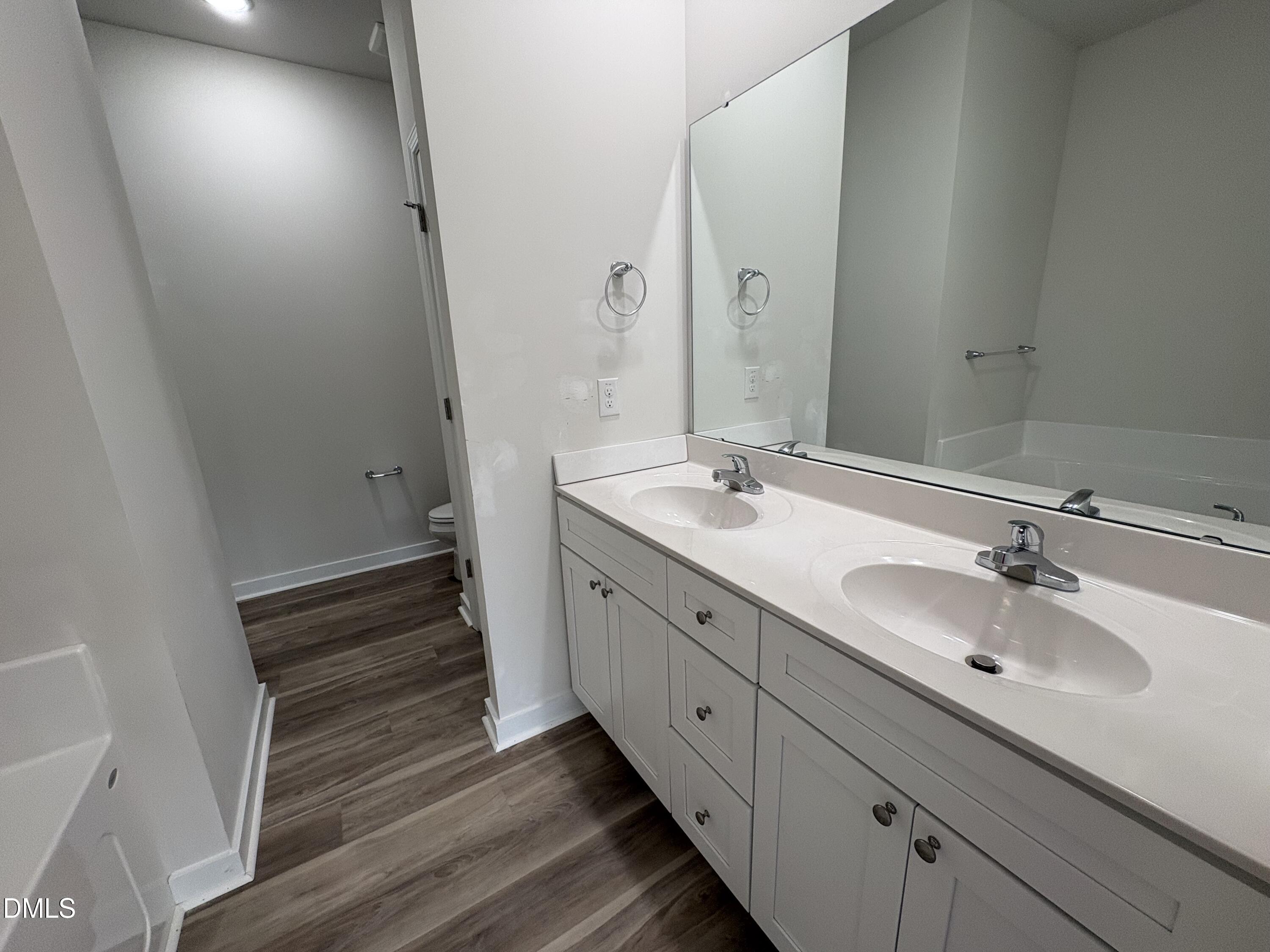 253 Jacobs Ridge Drive Four Oaks, NC 27524 - Photo 10 of 17 a bathroom with a double vanity sink and mirror with wooden floor