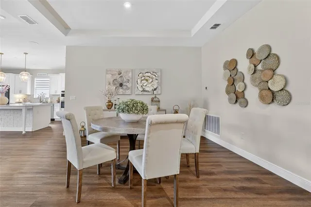 a view of a dining room with furniture a fireplace and wooden floor