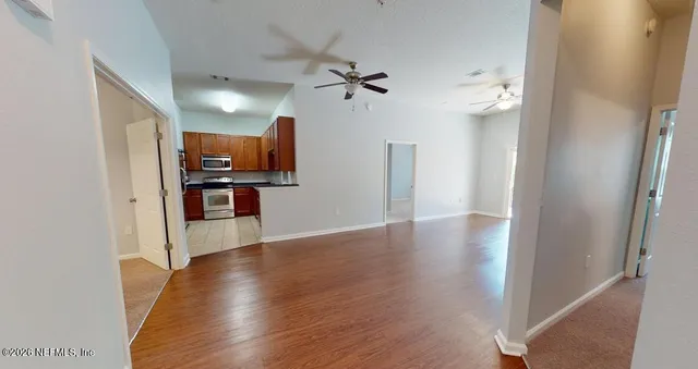 a view of a kitchen with wooden floor electronic appliances and stairs