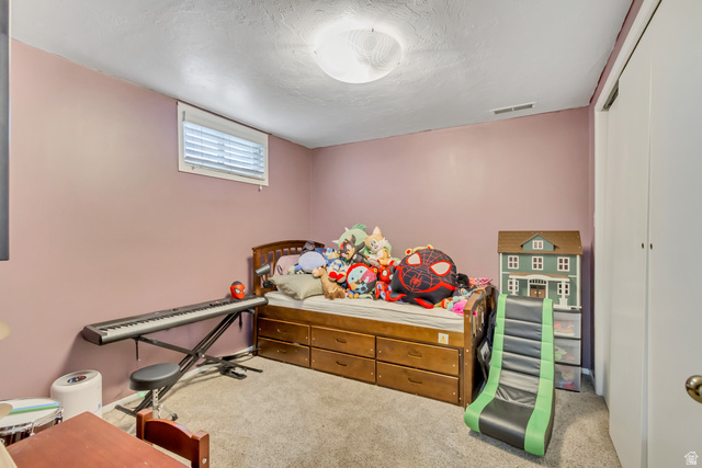 65 West 700 North Bountiful, UT 84010 - Photo 26 of 29 Carpeted room with a window, a built-in closet with double doors, and a ceiling-mounted light fixture