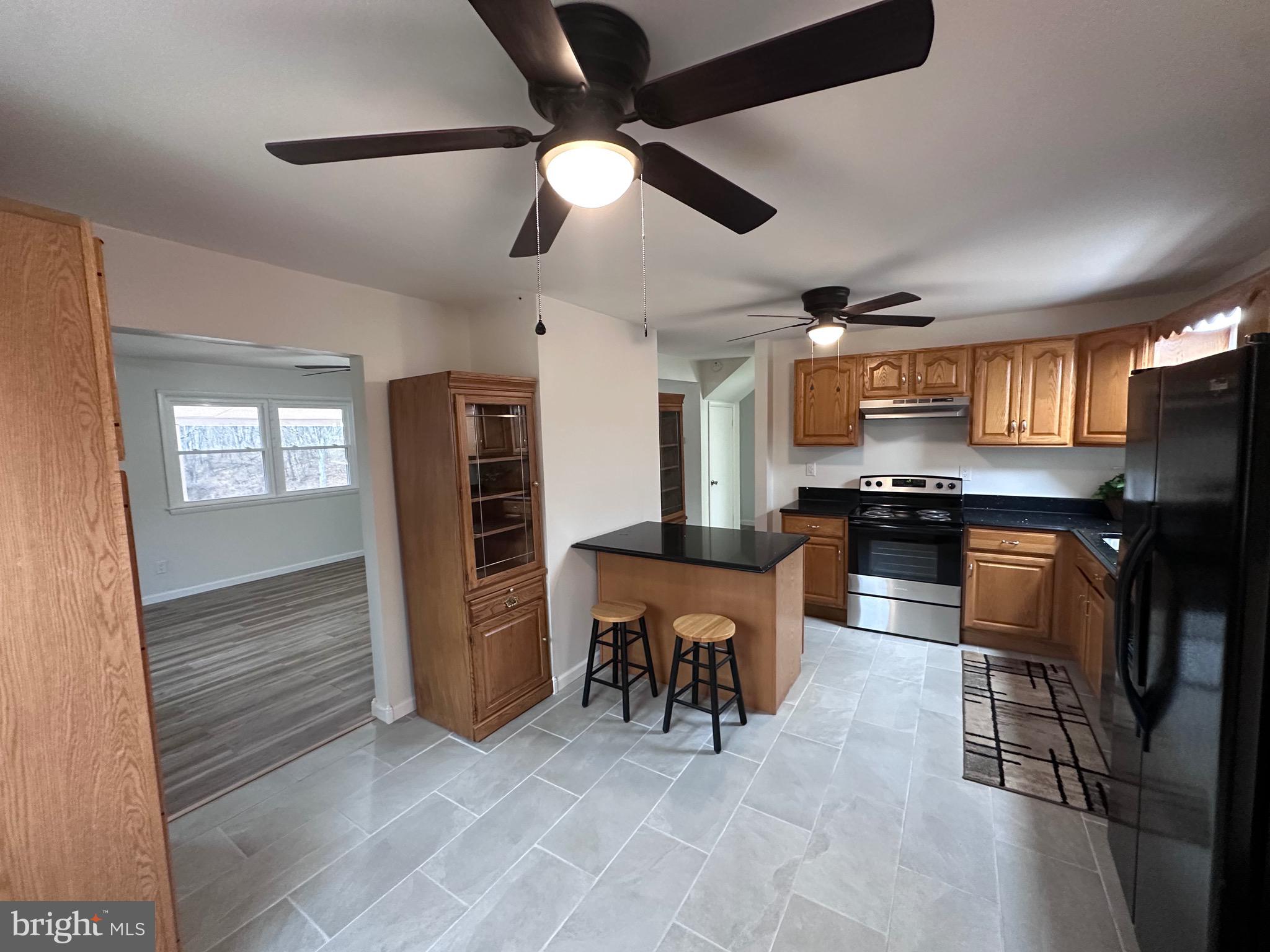 18712 Crossland Road Southwest Rawlings, MD 21557 - Photo 41 of 89 a kitchen with stainless steel appliances kitchen island granite countertop a refrigerator a stove a sink a dining table and chairs with wooden floor