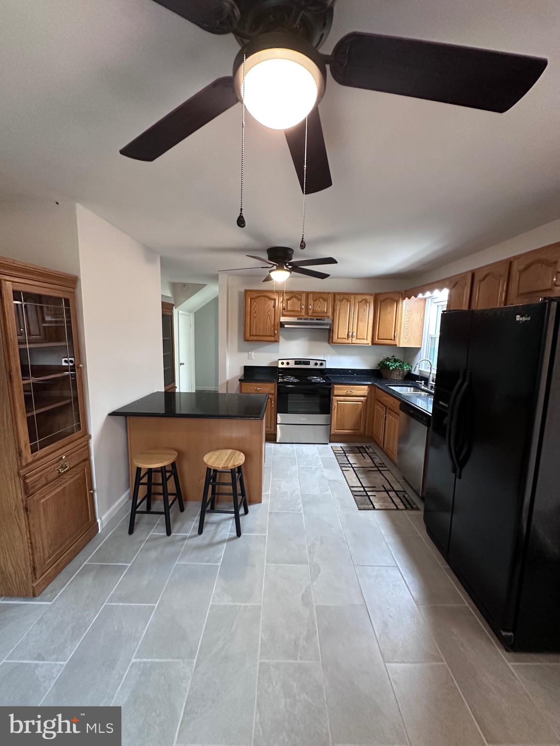 18712 Crossland Road Southwest Rawlings, MD 21557 - Photo 46 of 89 a large kitchen with stainless steel appliances kitchen island granite countertop a table chairs and a refrigerator