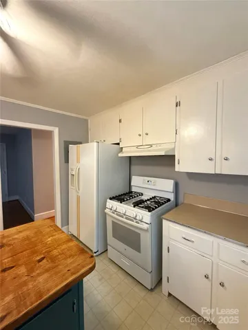 a kitchen with white cabinets and white appliances