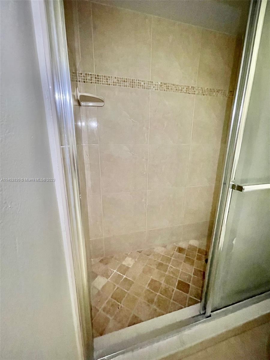 105 Meadows Circle, Unit 105 Boynton Beach, FL 33436 - Photo 15 of 18 a bathroom with a glass door shower and hardwood floor