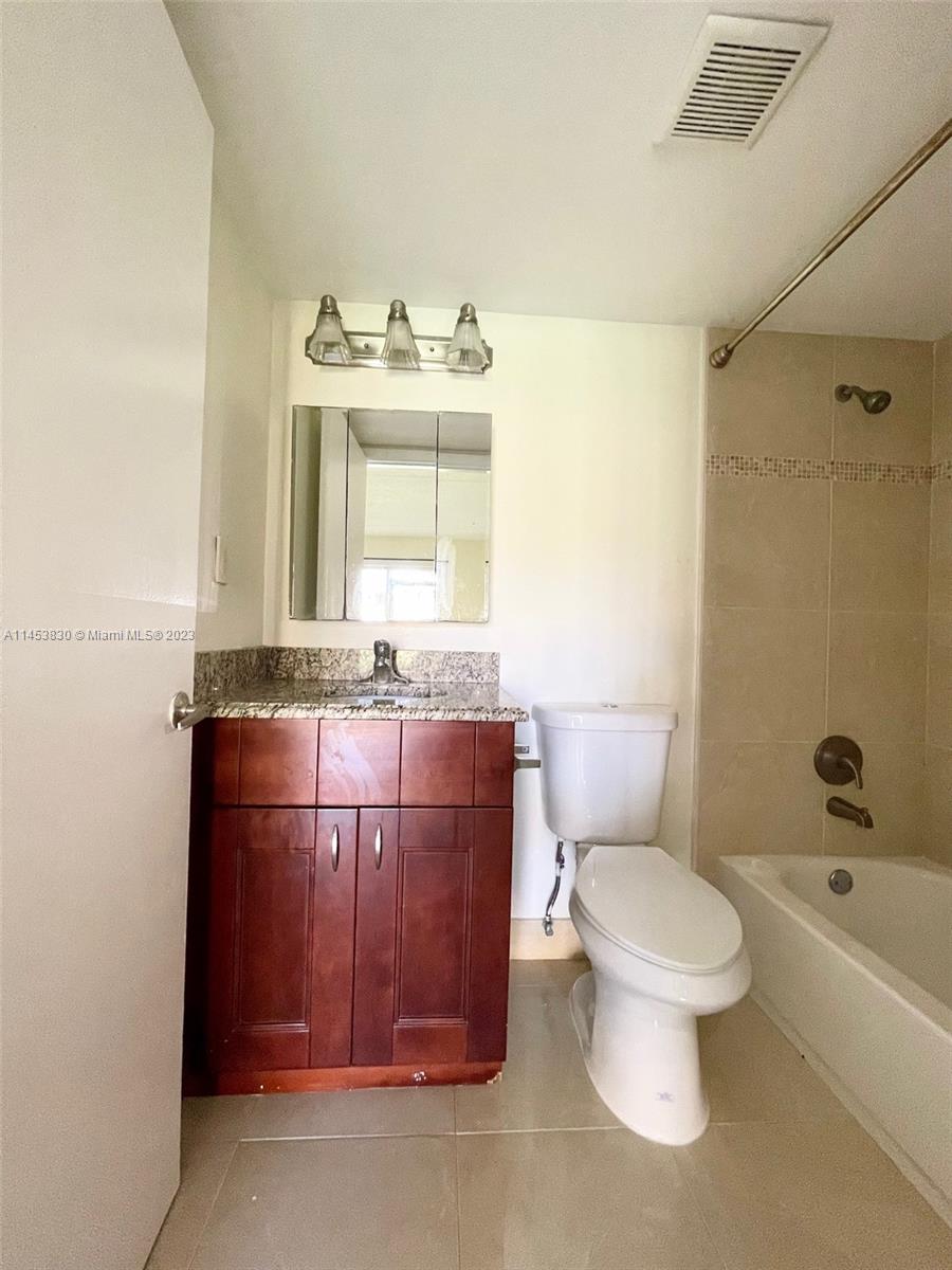 105 Meadows Circle, Unit 105 Boynton Beach, FL 33436 - Photo 18 of 18 a bathroom with a granite countertop toilet sink and mirror