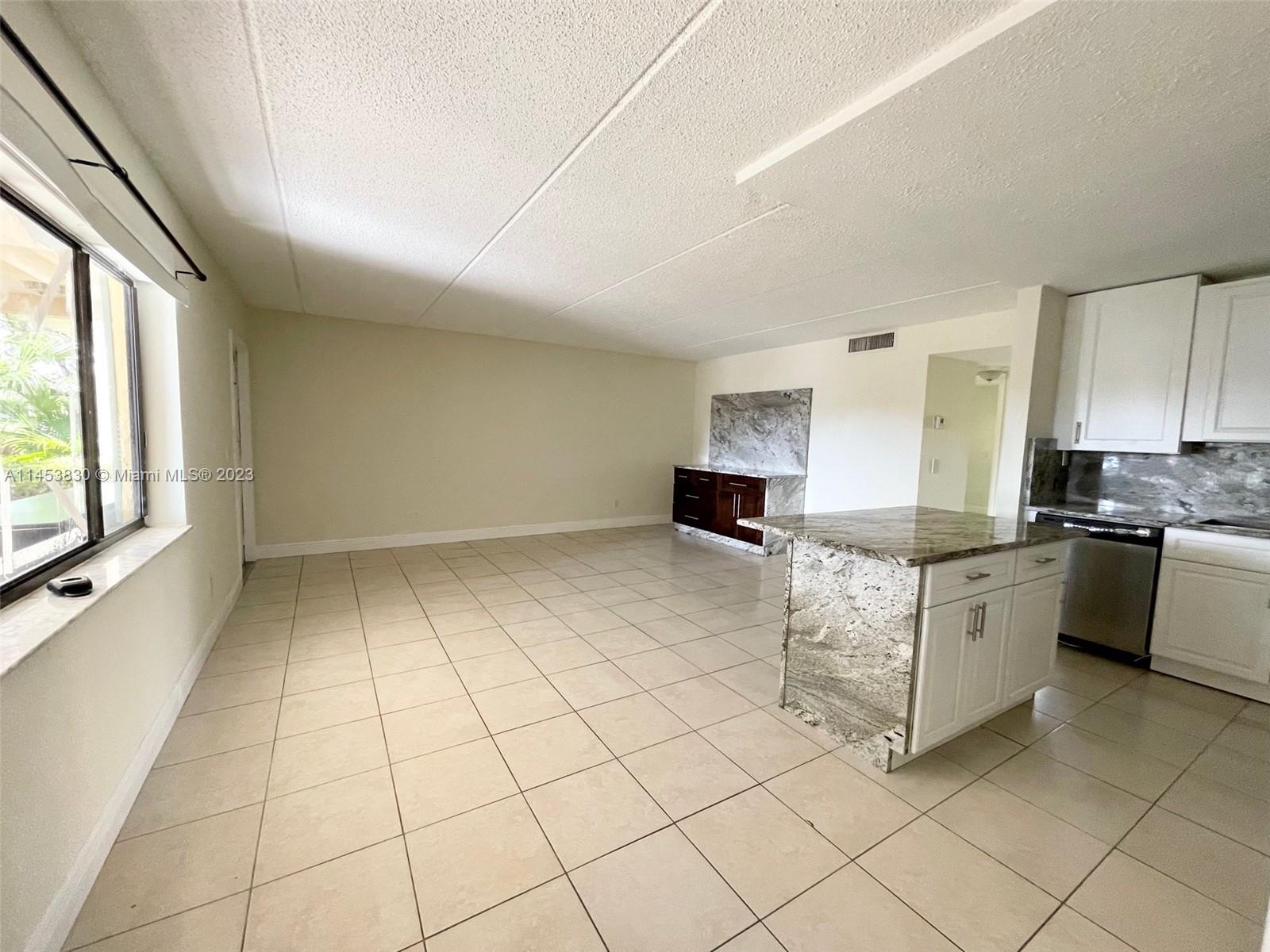 105 Meadows Circle, Unit 105 Boynton Beach, FL 33436 - Photo 9 of 18 a kitchen with cabinets and white appliances