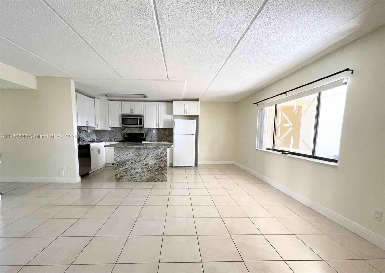 105 Meadows Circle, Unit 105 Boynton Beach, FL 33436 - Photo 10 of 18 a kitchen with stainless steel appliances a refrigerator sink and microwave