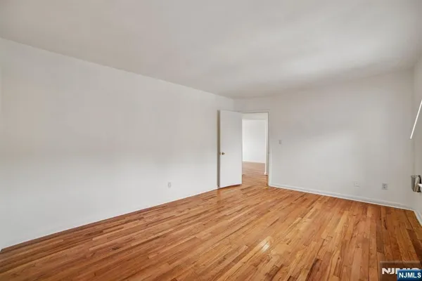 a view of an empty room with wooden floor