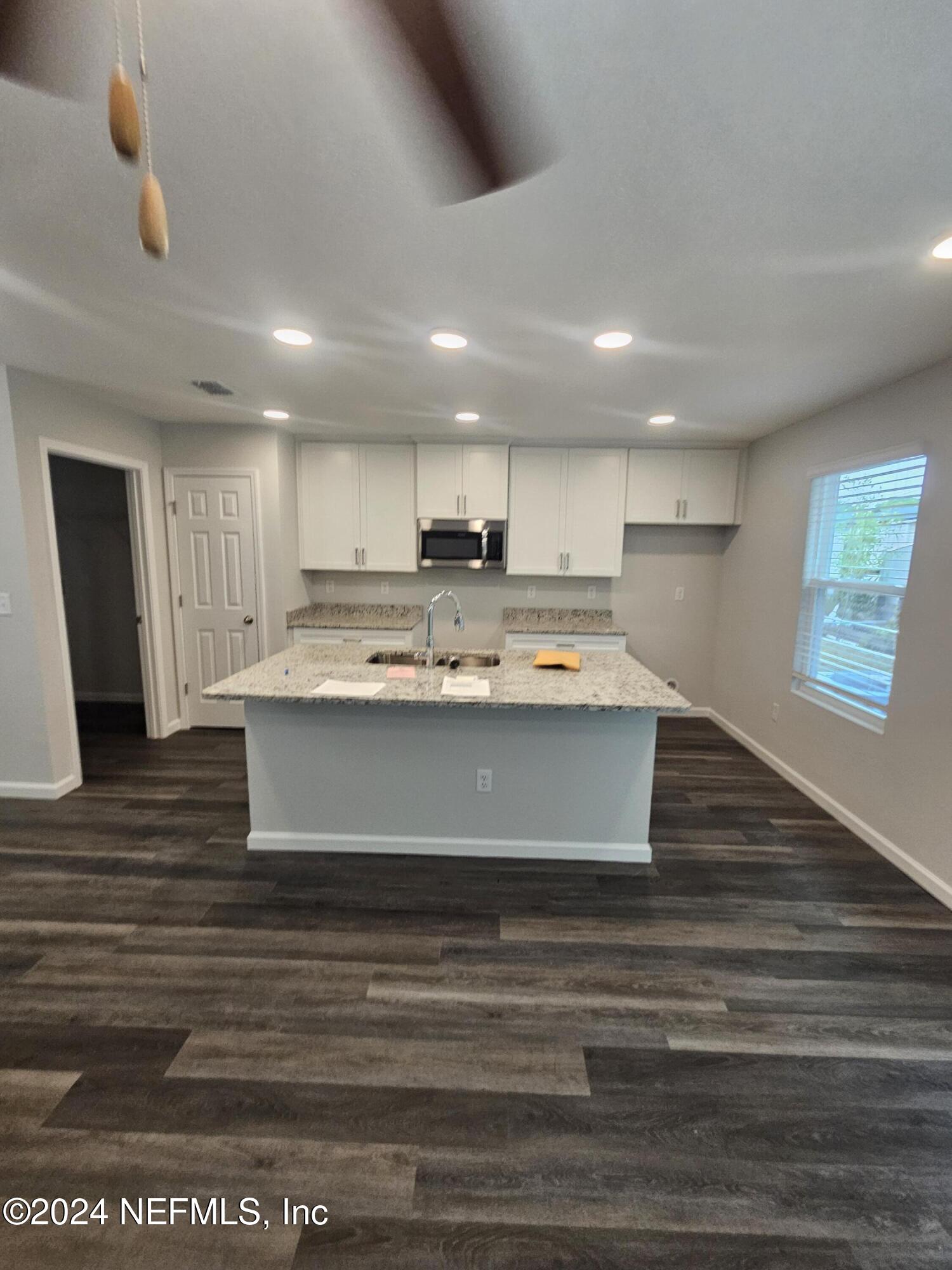 7607 Del Road Jacksonville, FL 32244 - Photo 5 of 15 a large white kitchen with kitchen island a sink stainless steel appliances and cabinets